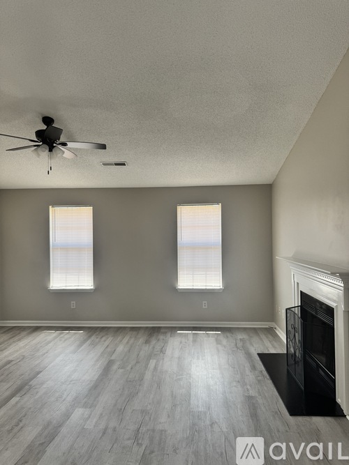 A living room with a fireplace and a ceiling fan.