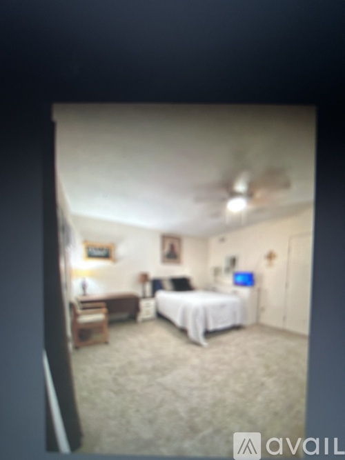 A bedroom with a bed, a couch, a chair, and a television.