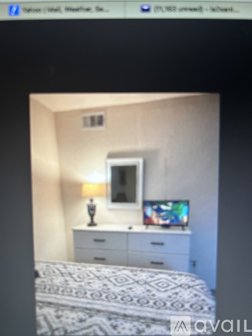 A bedroom with a bed, dresser, and mirror.