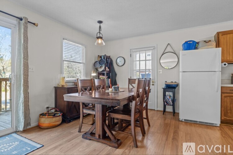 A kitchen with a table and chairs and a refrigerator.