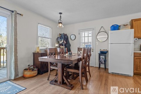 A kitchen with a table and chairs and a refrigerator.