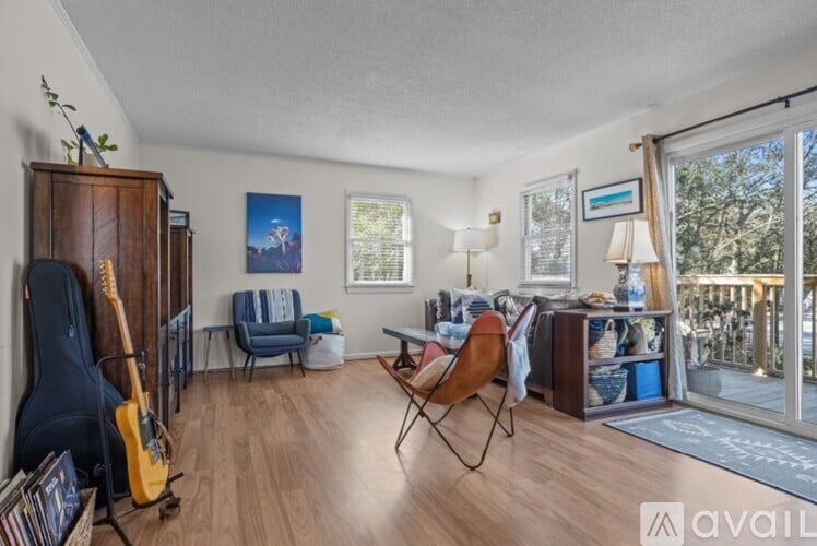 A living room with a guitar and a chair.