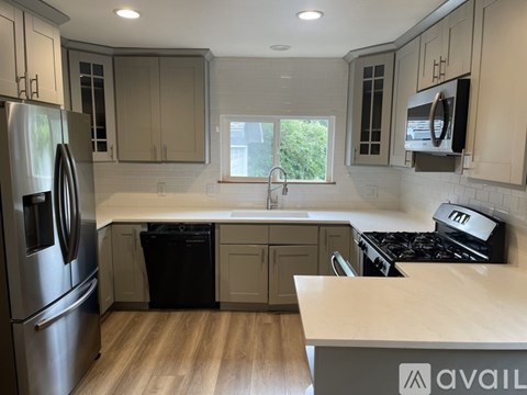 A kitchen with a refrigerator, stove, and cabinets.