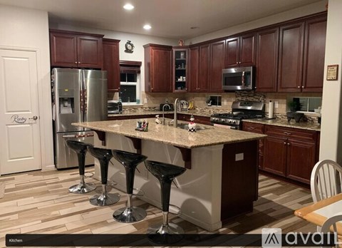 A kitchen with a granite countertop and a refrigerator.