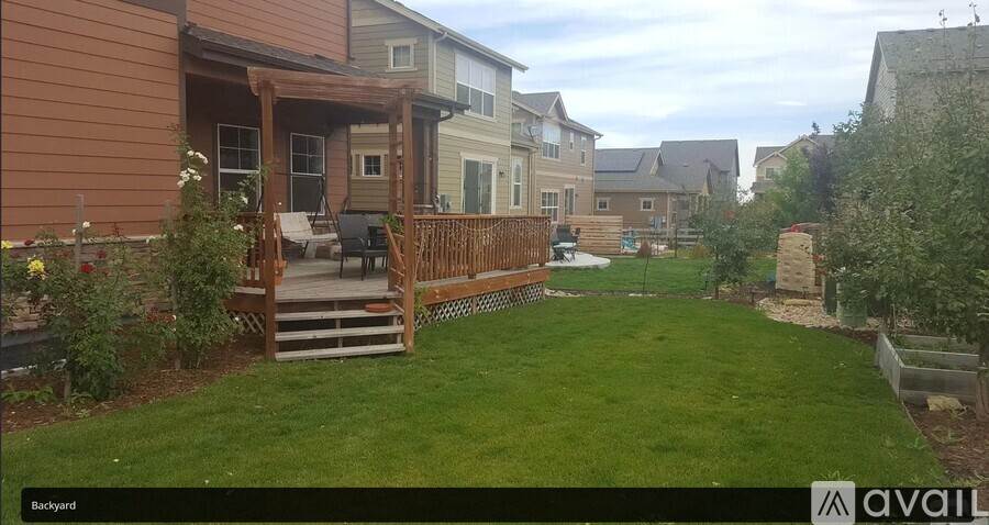 A backyard with a deck and a lawn.