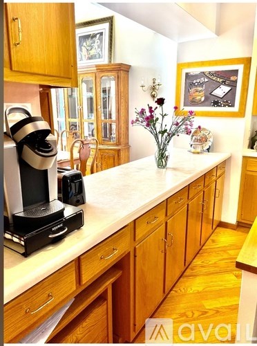 A kitchen with wooden cabinets and a coffee machine on the counter.