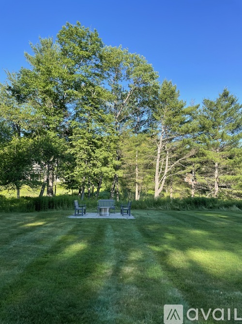 A park bench sits in the middle of a grassy field.