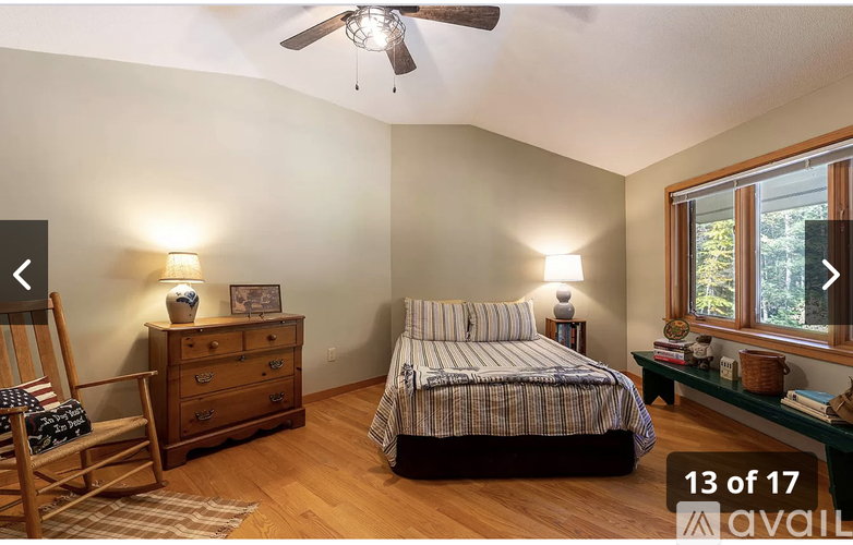 A bedroom with a bed, dresser, and chair.