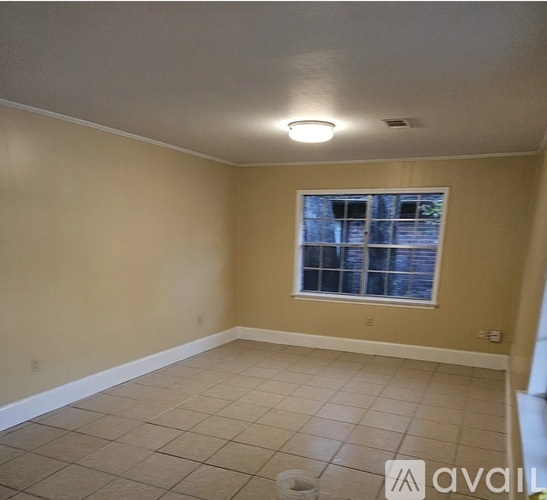 A room with a window and tiled floor.