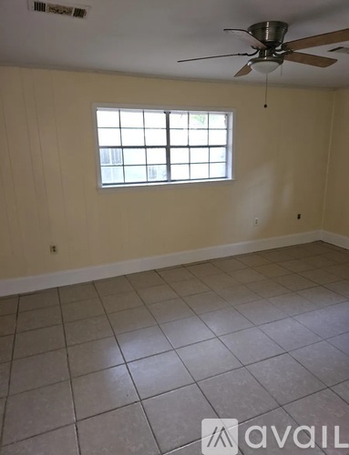 A room with a ceiling fan and a window.