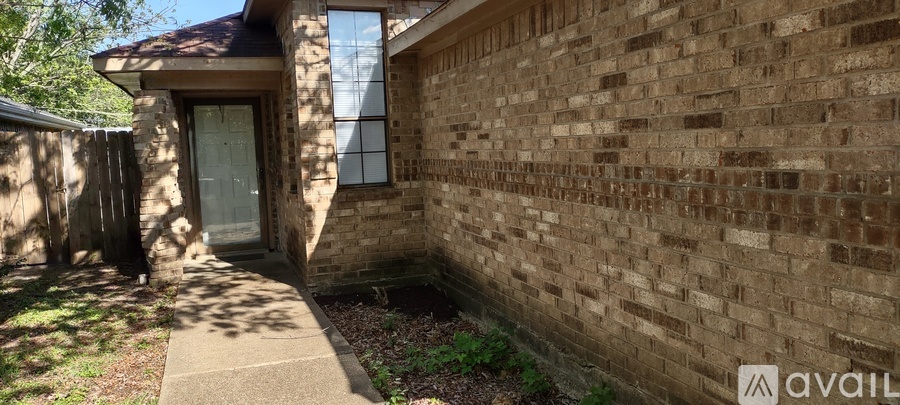 A brick house with a white door and a window.