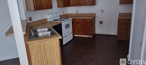 A kitchen with wooden cabinets and a white stove top oven.