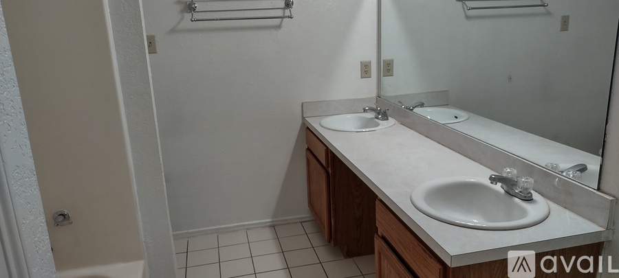 A bathroom with two sinks and a mirror.