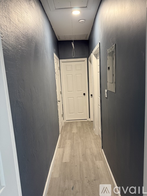 A hallway with a white door and a mirror on the wall.