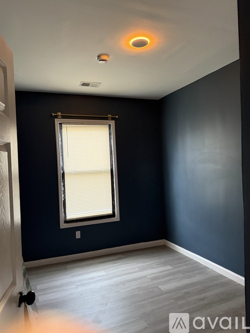 A room with a window and a ceiling light.