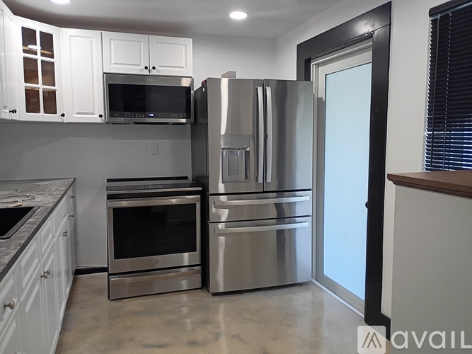 A kitchen with a stainless steel refrigerator, oven, and microwave.