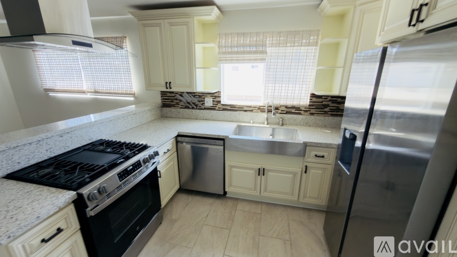 A kitchen with a stove top oven, dishwasher, and refrigerator.