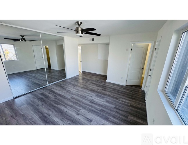 A spacious room with a ceiling fan and sliding glass doors.