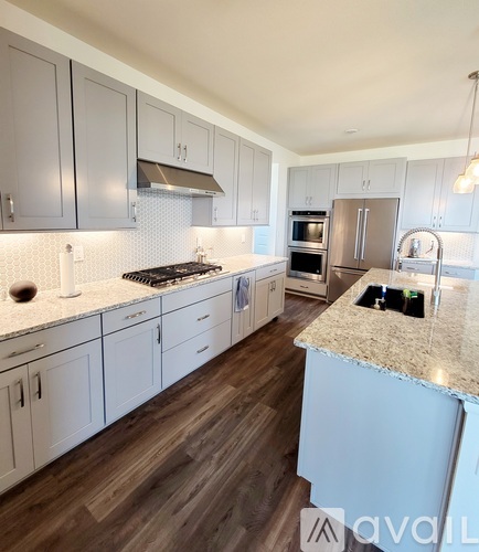 A kitchen with white cabinets and a granite countertop.