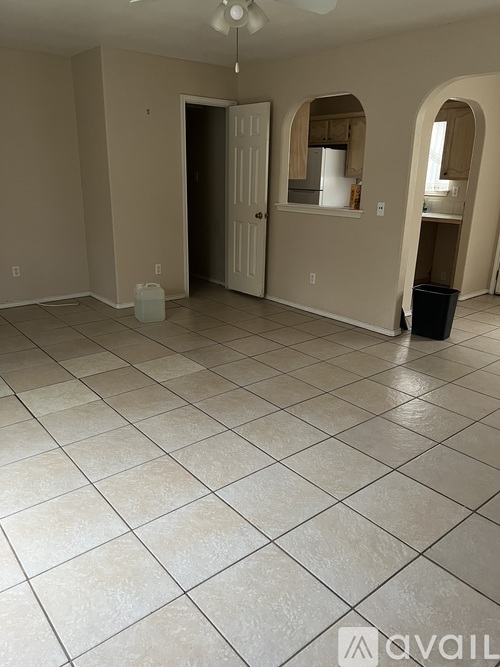A spacious room with beige walls and a white door.
