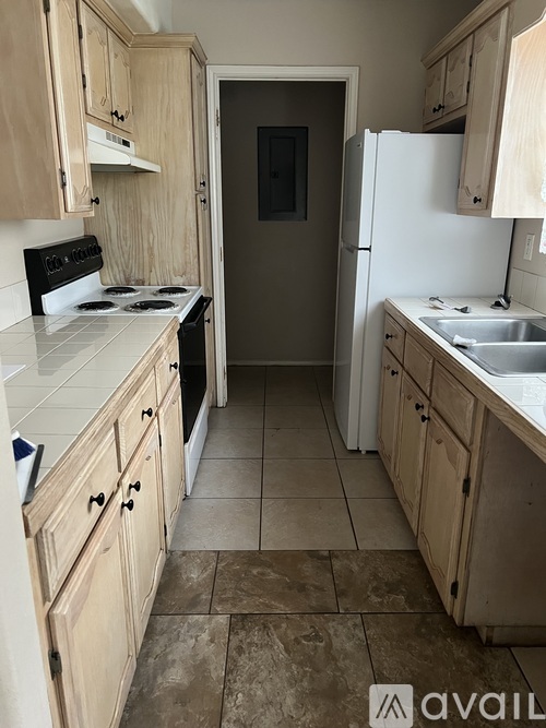 A kitchen with wooden cabinets and a tiled floor.