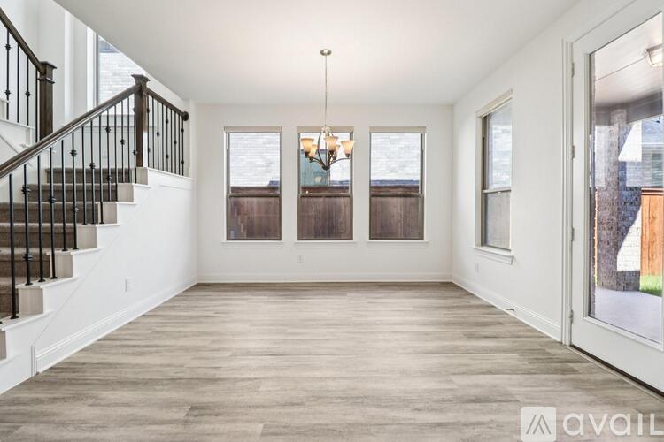 A spacious room with a staircase and a chandelier.