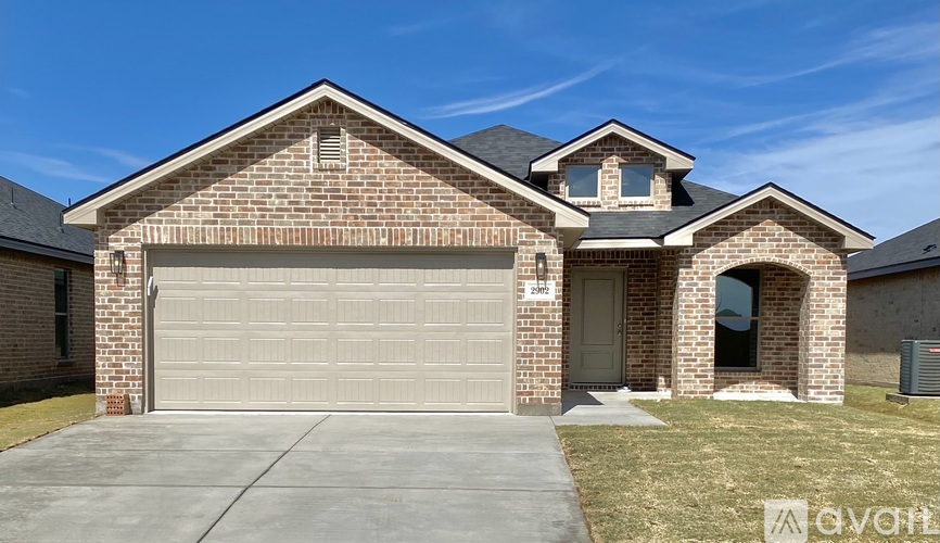 A brick house with a garage door and a small window above the door.