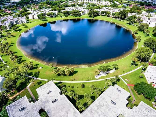 A large lake is surrounded by buildings and trees.