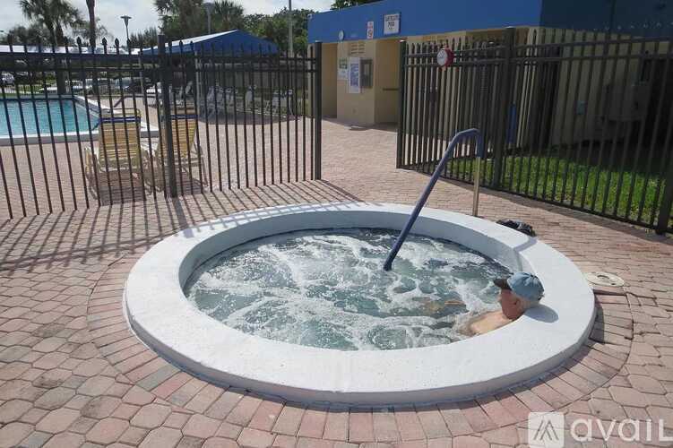 A man is sitting in a hot tub on a patio.