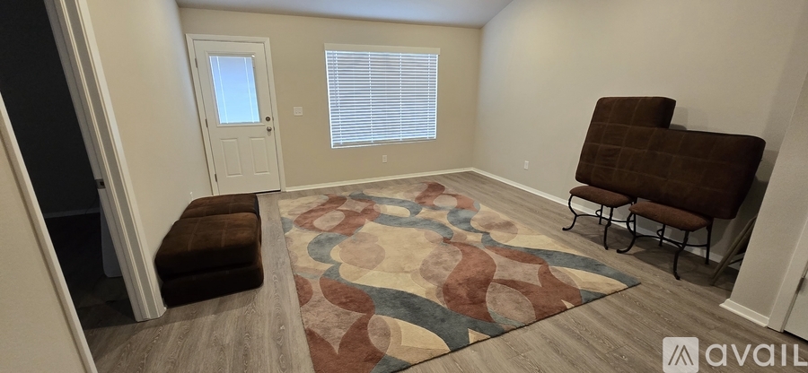 A room with a brown chair and a rug with a pattern on it.