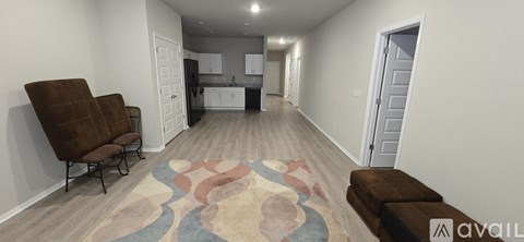 A living room with a brown couch and a rug.