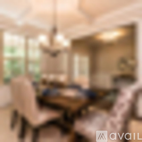A blurry image of a dining room with a table and chairs.