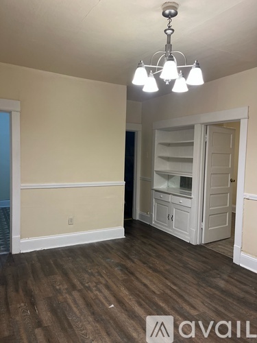 A room with wooden floors and a chandelier.