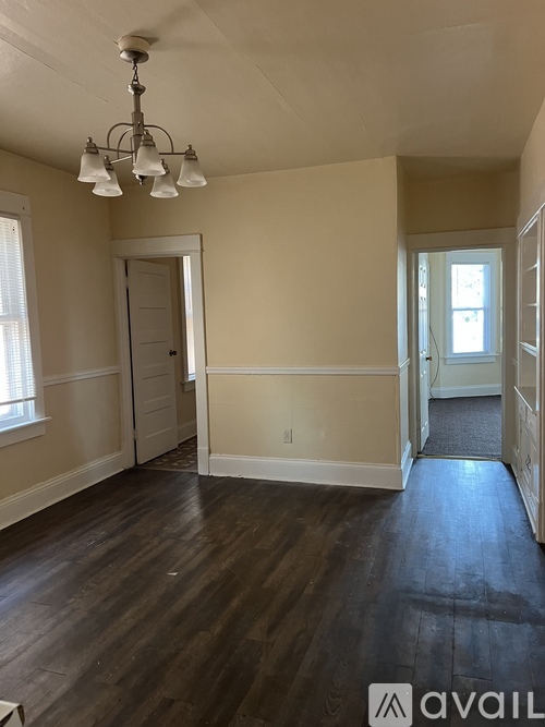 A room with wooden floors and a chandelier.