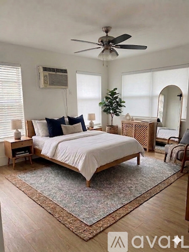 A bedroom with a large bed and a ceiling fan.
