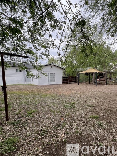 A yard with a house and a gazebo.