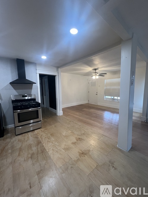 A kitchen with a stove top oven and a fan.