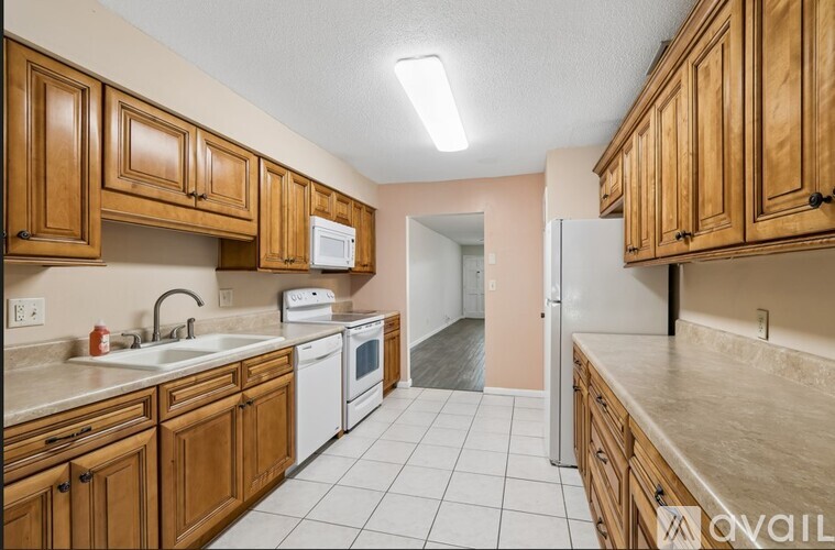 A kitchen with wooden cabinets and white appliances.