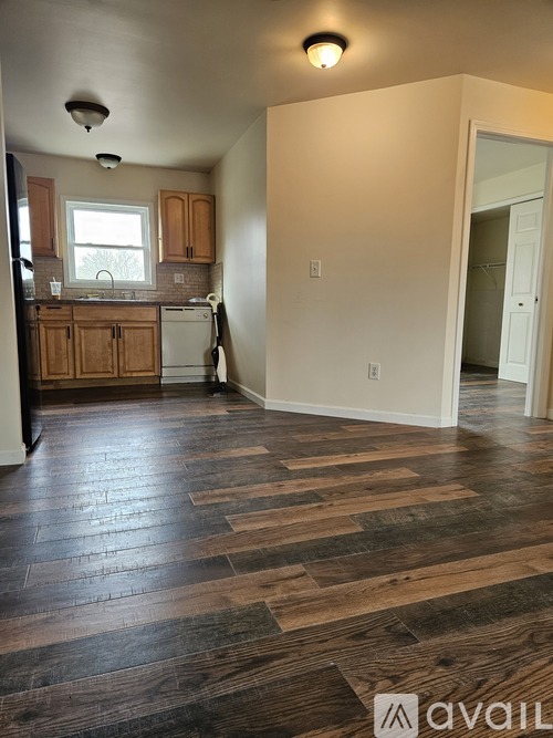 A kitchen with wooden floors and white walls.