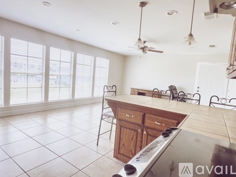 A kitchen with a stove top oven and a fan.