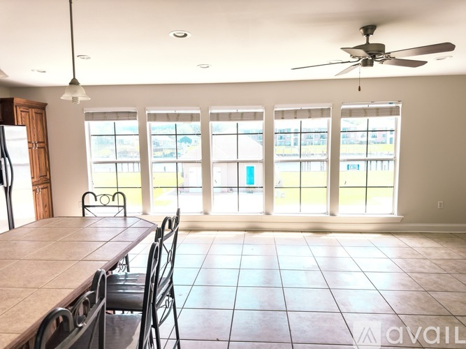 A dining room with a table and chairs and a ceiling fan.