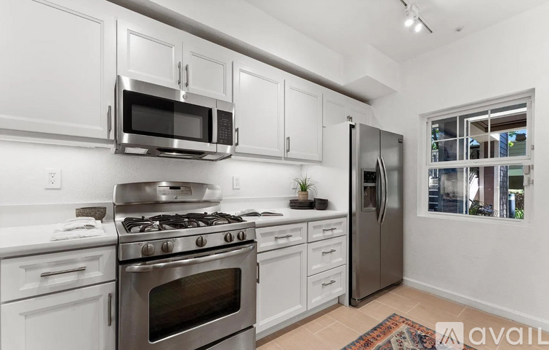A kitchen with white cabinets and stainless steel appliances.