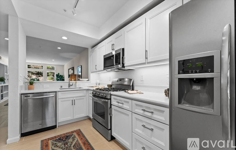 A modern kitchen with stainless steel appliances and white cabinets.