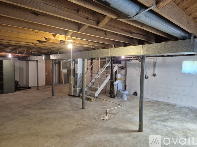 A room under construction with exposed wooden beams and unfinished walls.