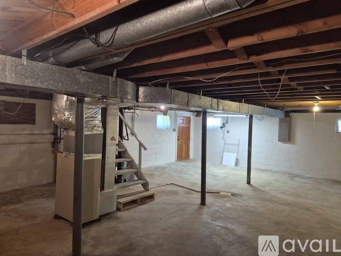 A room with a staircase and a furnace.