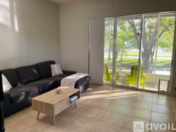 A living room with a black couch and a coffee table.