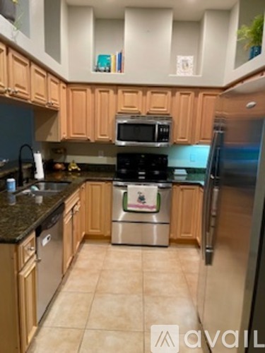 A kitchen with wooden cabinets and a black countertop.