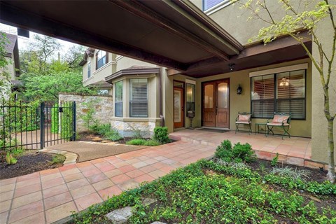 A house with a patio and a black fence.
