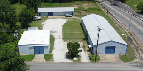 A large industrial complex with two buildings and a parking lot.