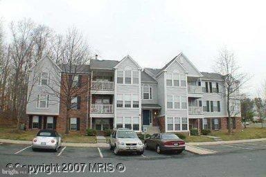 Apartment building with cars parked in front.